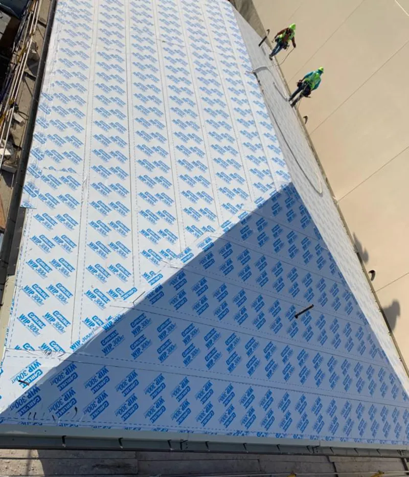 Professional roofers installing underlayment on a metal roof in Inverness